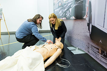 Two people near a manikin.