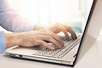 hands typing on a laptop computer