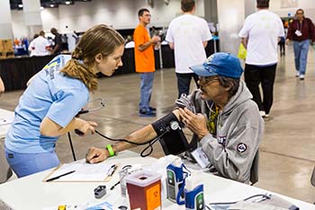 A student taking a patient's blood pressure.
