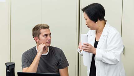 A student listens to a professor.