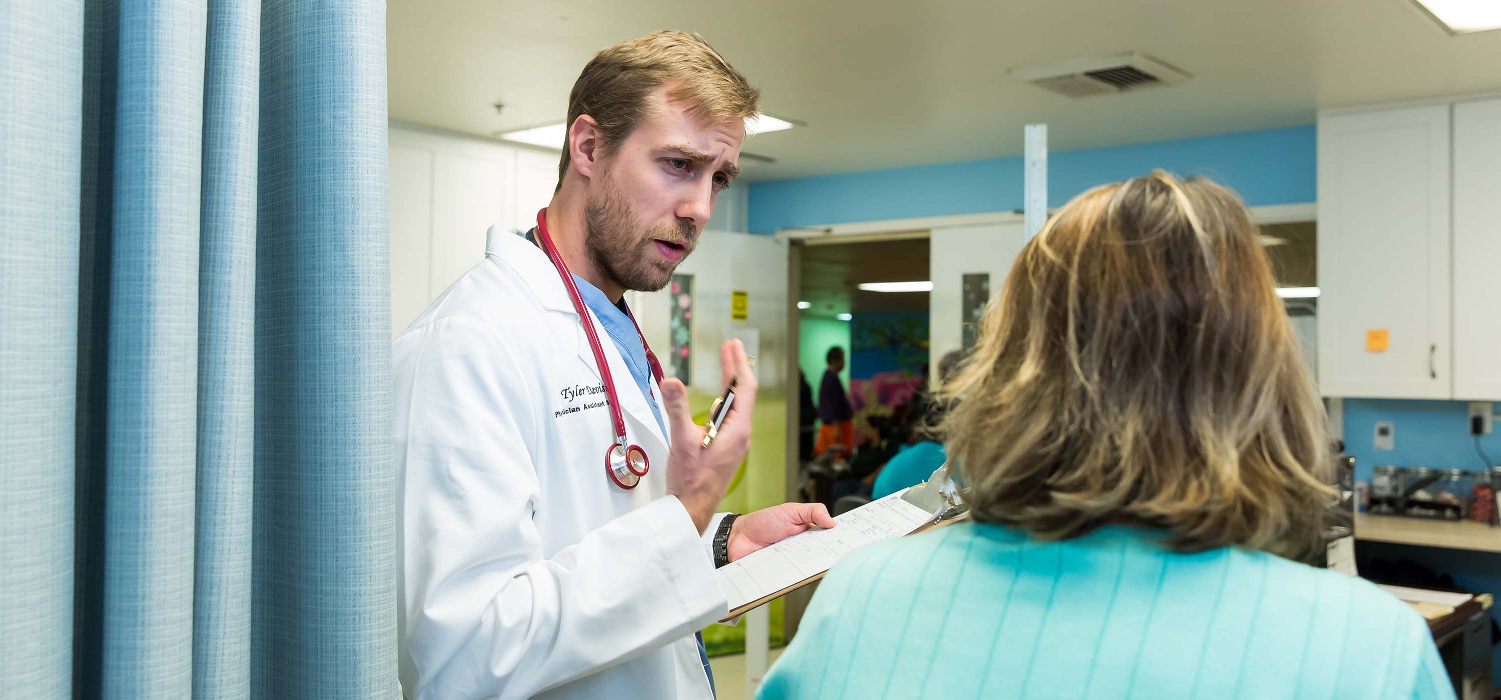 A physician assistant studies student talks to a patient.