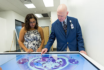 Two people at the anatomage table.