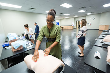 A woman with a task trainer. 