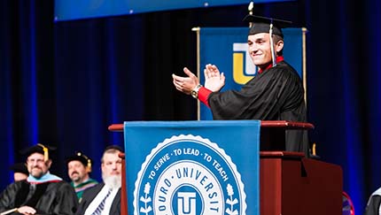A student at the podium during commencement.