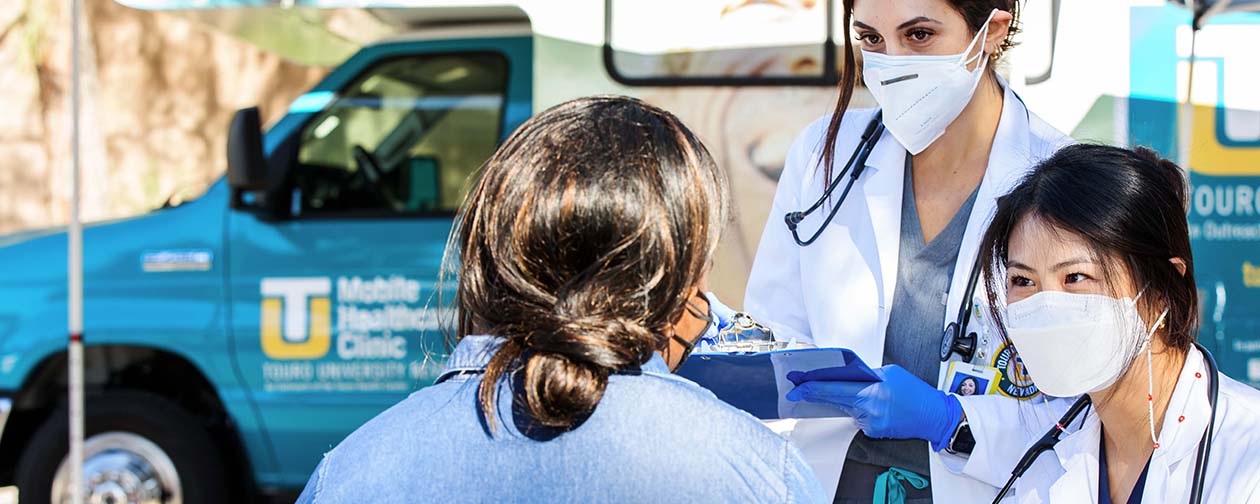 Volunteer Touro students speaking with a patient at Project Homeless Connect